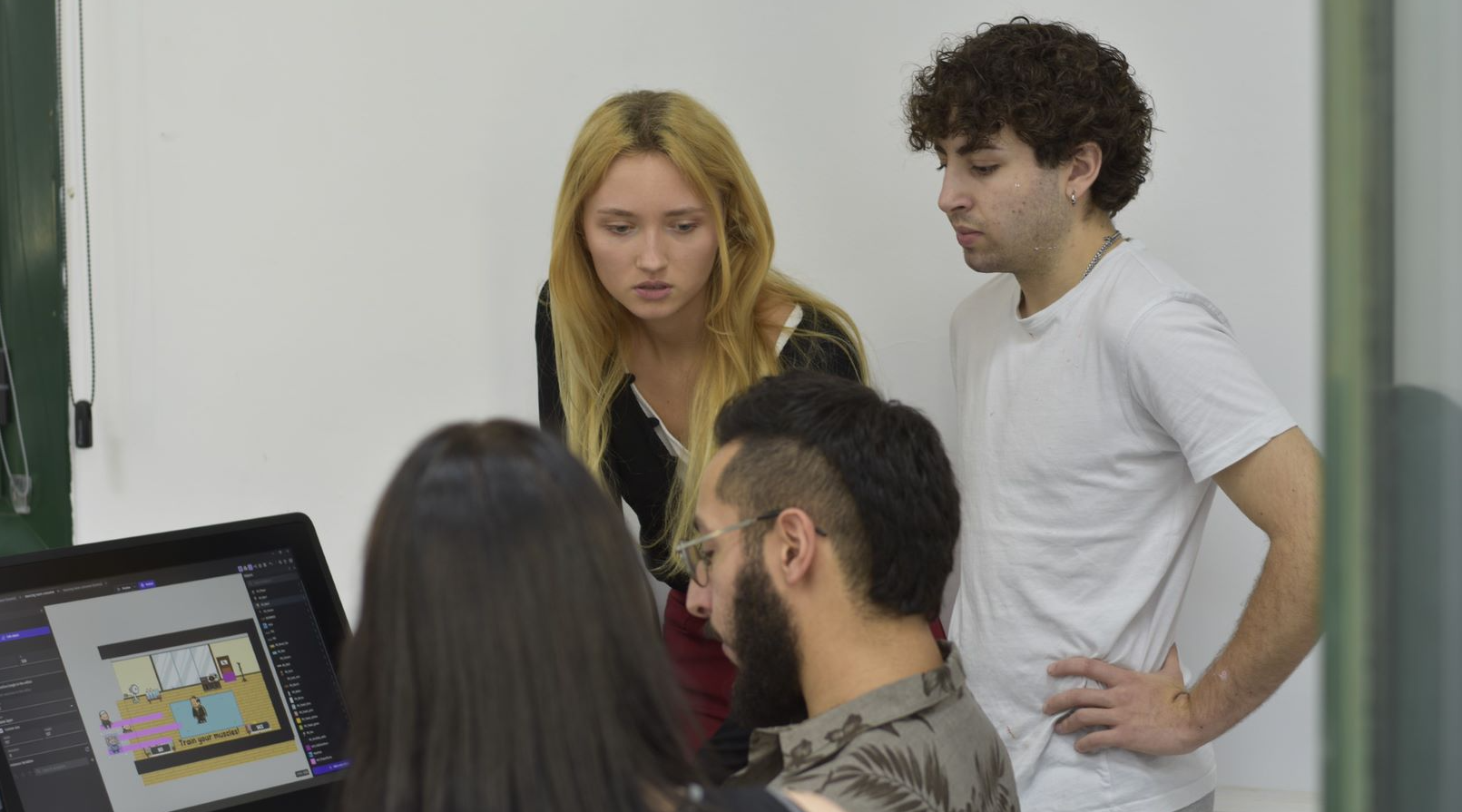 Adriana and Elio showing Kpop Trainee Simulator to their teacher Eduardo. 